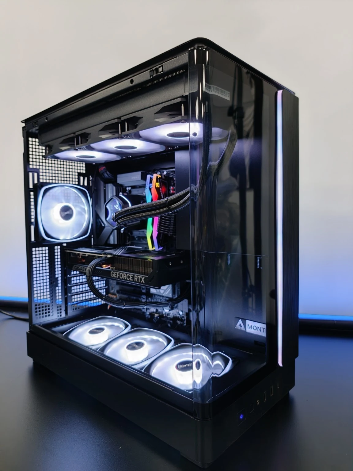 PC a medida reciente con iluminación blanca y azul, montado en el taller de New Home PC